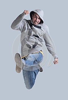 Funny cheerful happy man jumping in air over gray background