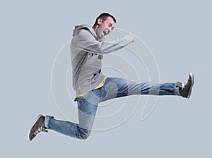 Funny cheerful happy man jumping in air over gray background