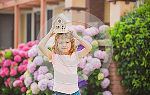 Funny child boy dreaming about a new house or home.