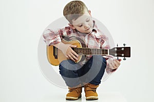 Funny child boy with guitar. country boy playing music