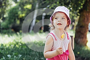 Funny child with candy lollipop, happy little girl eating big