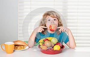 Funny child eating apple. Kid preteen boy 7, 8, 9 years old eating healthy food vegetables. Breakfast with milk, fruits