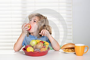 Funny child eating apple. Little child boy having healthy breakfast. Kids nutrition and development. Eating vegetables