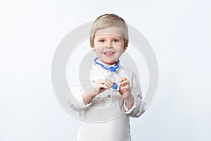 Funny child family doctor with stethoscope on white background with copy space