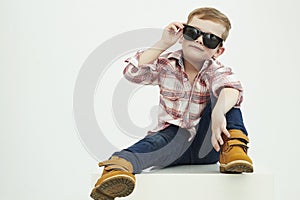 Funny child. fashionable little boy in sunglasses. stylish kid in yellow shoes