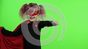 Funny child girl in costume and mask plays super hero. National superhero day
