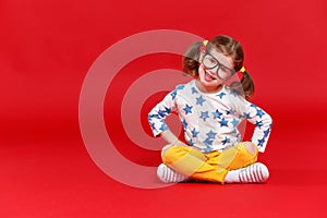 Funny child girl in glasses on colored background