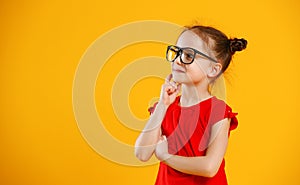 Funny child girl in glasses on colored background
