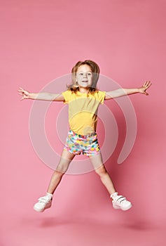 Funny child girl jumping on a colored background