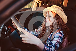 funny child girl playing driver, sitting on front seat