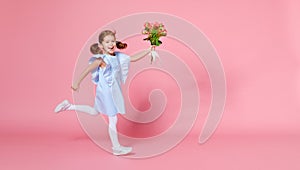 Funny child girl runs and jumps with bouquet of flowers on color