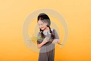 Funny child girl smiling with bouquet of flowers on a coloured background