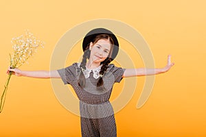 Funny child girl smiling with bouquet of flowers on a coloured background