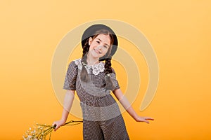 Funny child girl smiling with bouquet of flowers on a coloured background