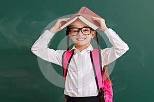 Funny child   girl student with book about school blackboard