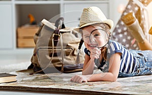 Funny child girl tourist with world map, backpack and magnifier