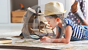 Funny child girl tourist with world map, backpack and magnifier