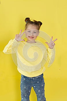 Back to school, funny child girl yellow jacket on a yellow background, sitting, reading a book, development and school