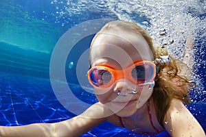 Funny child in goggles dive in swimming pool