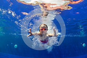 Funny child in goggles dive in swimming pool