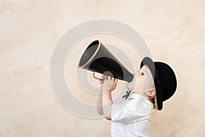 Funny child playing with black retro megaphone