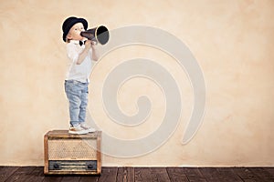 Funny child playing with black retro megaphone photo