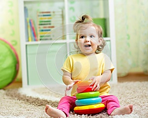 Funny child playing with color toy indoor