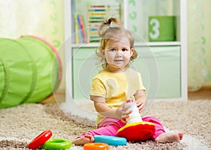 Funny child playing with color toy indoor