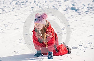 Funny child playing with snow in winter. Little girl in colorful jacket and knitted. Kids play in snowy forest. Children