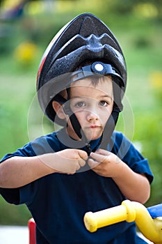 Funny child putting helmet