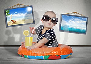 Funny child rest on swimming ring at home, as on the beach. Vacation creative concept