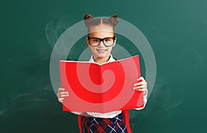 Funny child   schoolgirl girl student with book about school blackboard