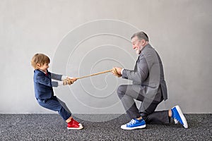 Funny child and senior man pretend to be businessmen