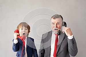 Funny child and senior man pretend to be businessmen