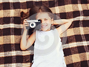 Funny child shooting vintage old retro camera and having fun