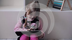 Funny child sitting on floor and using electronic devices.