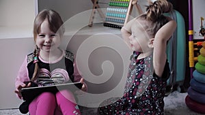 Funny child sitting on floor and using electronic devices.