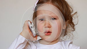Funny child speaks on the smartphone closeup. Baby girl talking on the mobile phone.