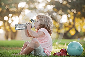 Funny child sport. Drinking water concept. Kid boy with bottle of water. Kid with drink water in park. Children