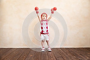 Funny child sportsman holding dumbbell