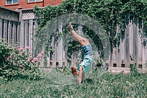 Funny child teenage girl doing cartwheel upside down stand. Excited joyful kid playing outdoors. Happy lifestyle childhood and