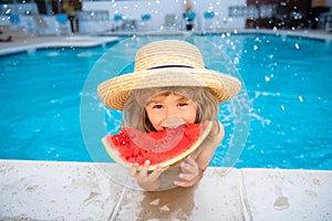 Funny child with watermelon. Kid having fun in swimming pool. Summer vacation and healthy eating.