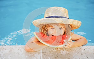 Funny child with watermelon. Kid having fun in swimming pool. Summer vacation and healthy eating.