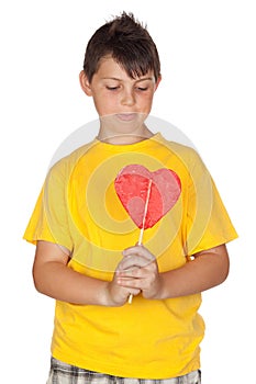 Funny child with yellow t-shirt with a lollipop