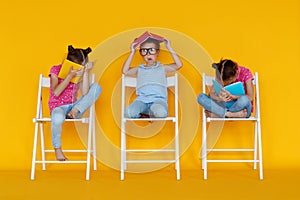 Funny children girls read books on colored yellow background