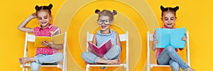 Funny children girls read books on a colored yellow background