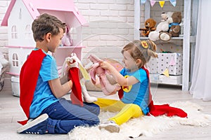 Funny children play with toys in the superheroes, in the children room