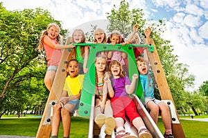Funny children on playground chute with arms up photo