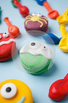 Funny children`s treats for Halloween: variations of macaroon, decorated in the form of different monsters, ghosts. Cooking proce