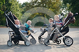 Funny children sitting in strollers in park